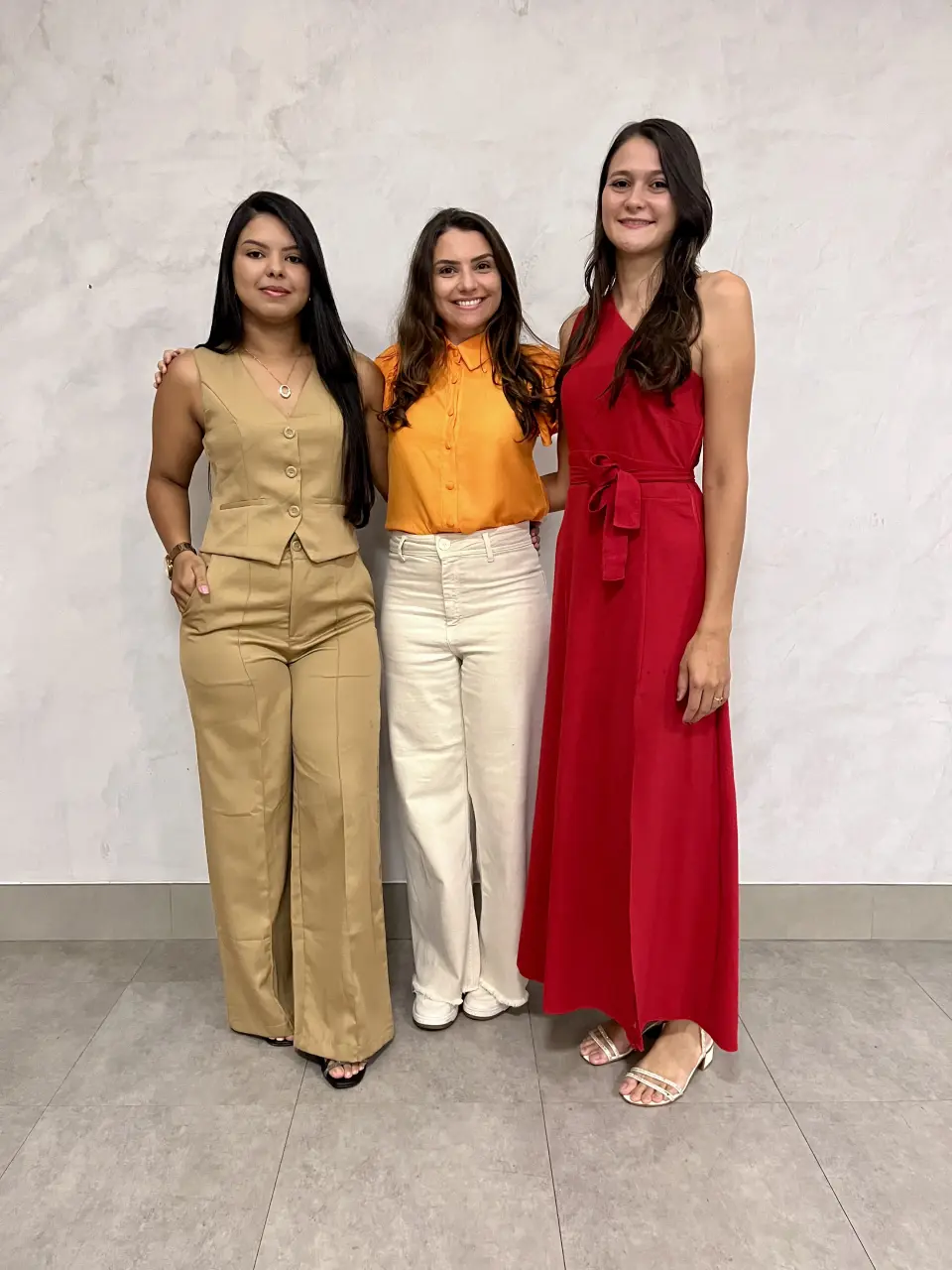 Três fisioterapeutas da equipe Longevidade, lado a lado e sorrindo.
